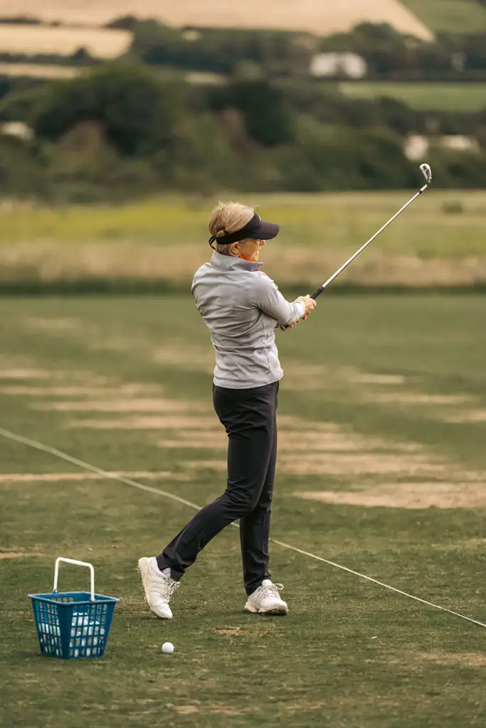a lady playing golf with an iron club